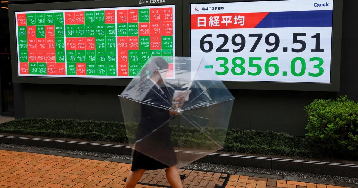Un piéton passe devant un panneau d’affichage boursier indiquant l’indice Nikkei, à l’extérieur d’une société de courtage à