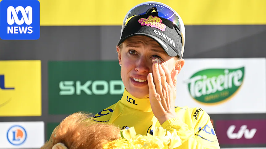 A woman wipes a tear from her eye while standing on a podium