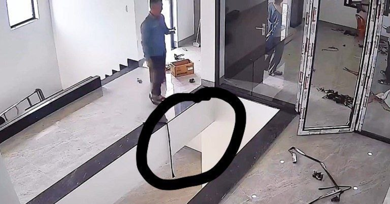 Operario caminando en obra con teléfono y abertura visible