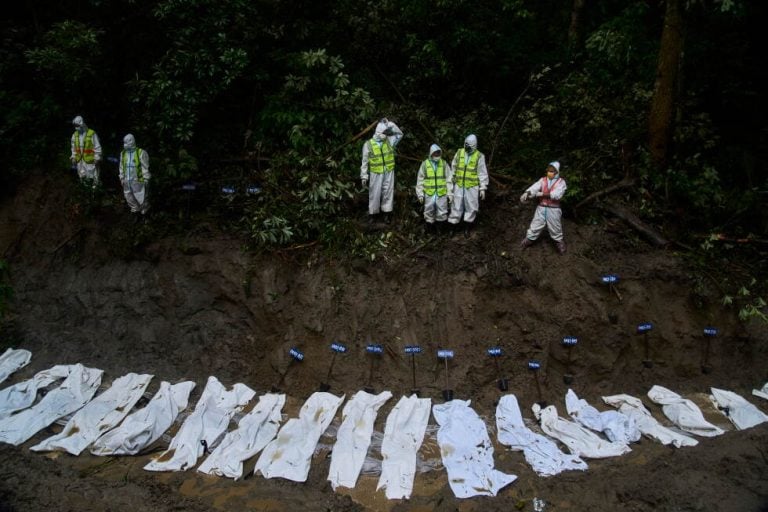 Nepal police personnel prepare the bodies of flash flood victims for a mass burial in Kathmandu, Nepal, Tuesday, Sept. 1