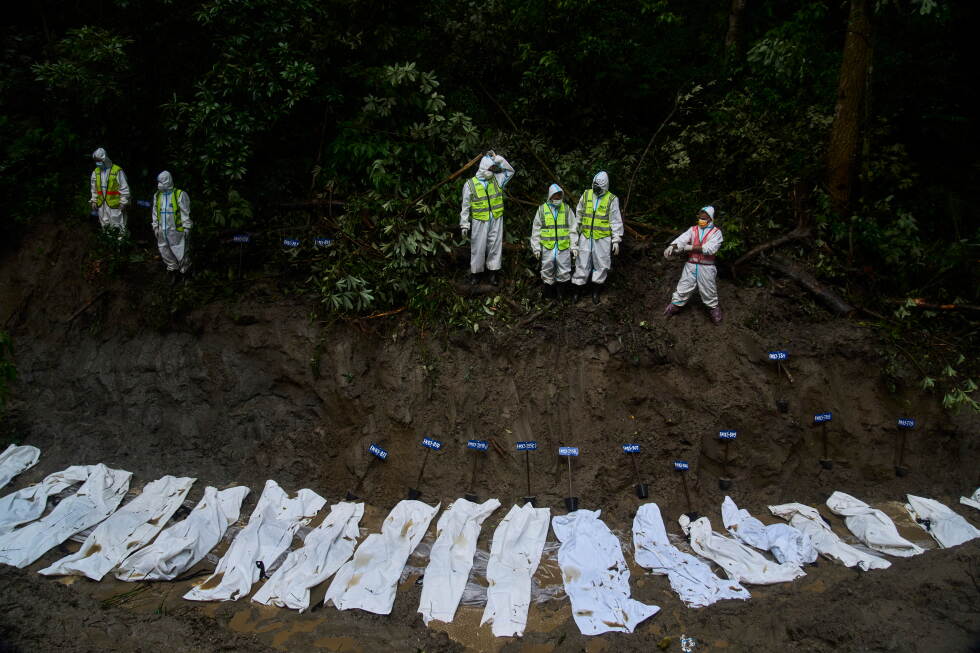 Nepal police personnel prepare the bodies of flash flood victims for a mass burial in Kathmandu, Nepal, Tuesday, Sept. 1