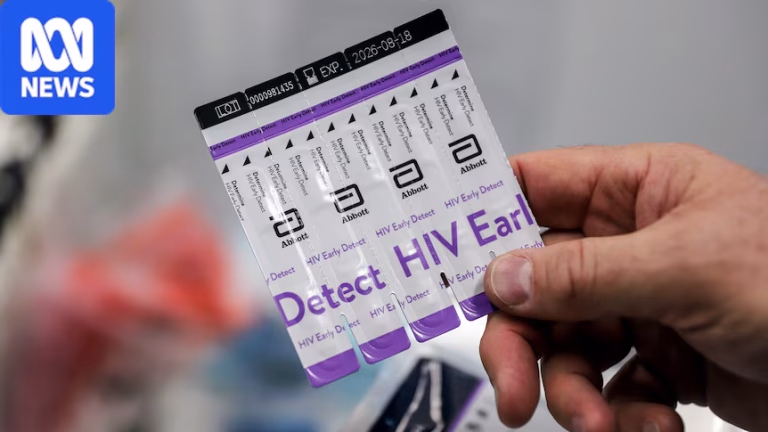 A hand holds a packet of HIV tests with purple font on white background