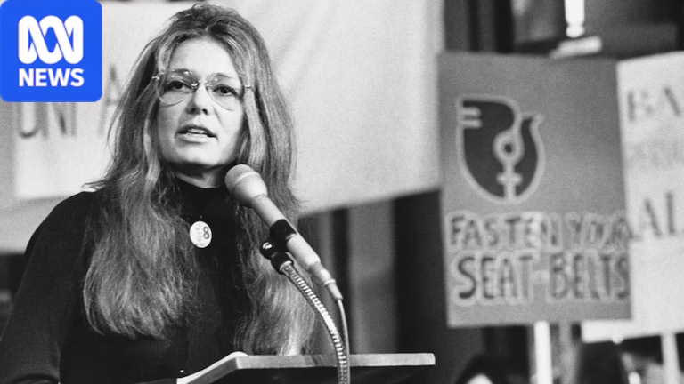 A woman in glasses speaks at a podium