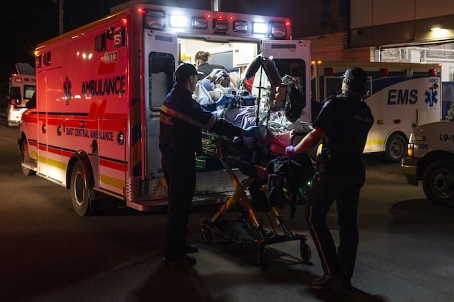 Des ambulanciers chargent un blessé dans leur ambulance au Wainwright Health Centre alors que des soldats blessés reçoivent